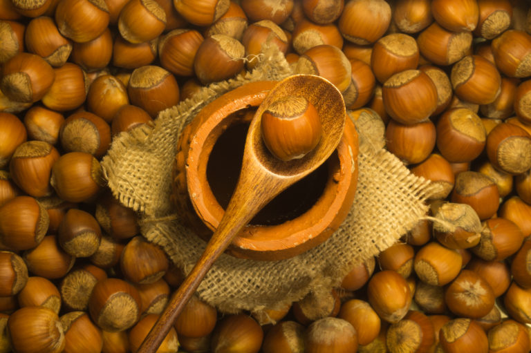 Honey pot with wooden spoon and nuts