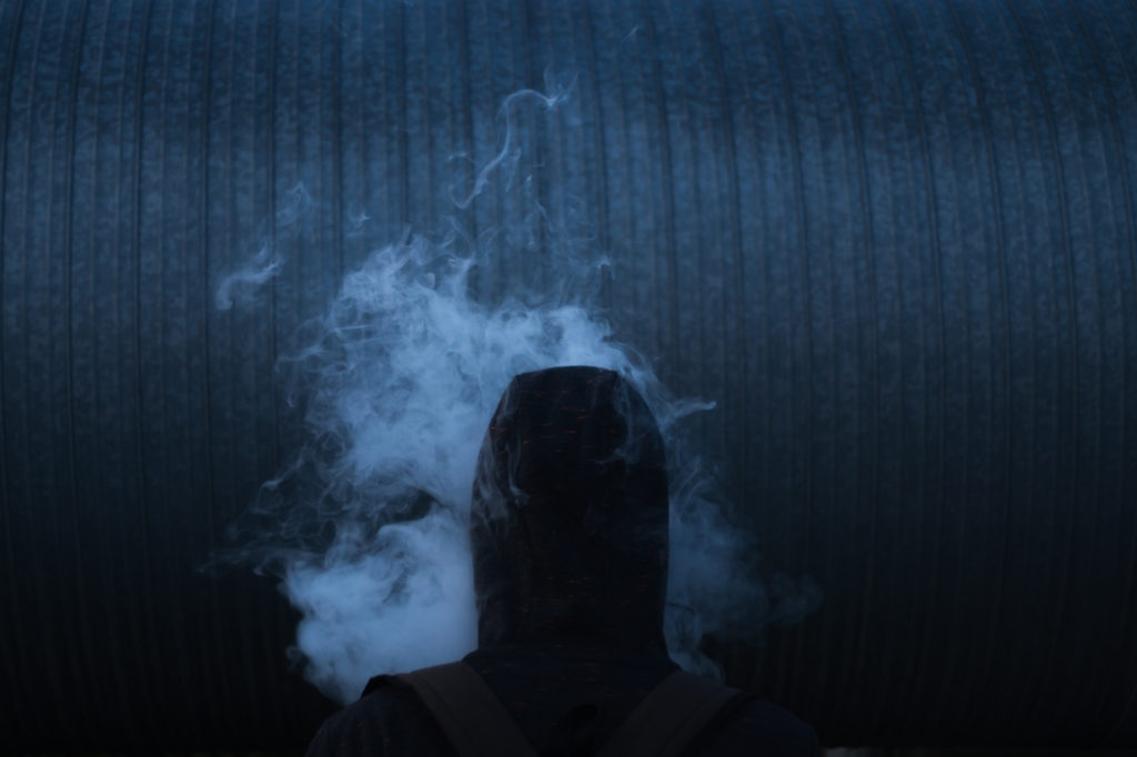 Man in smoke on the dark background